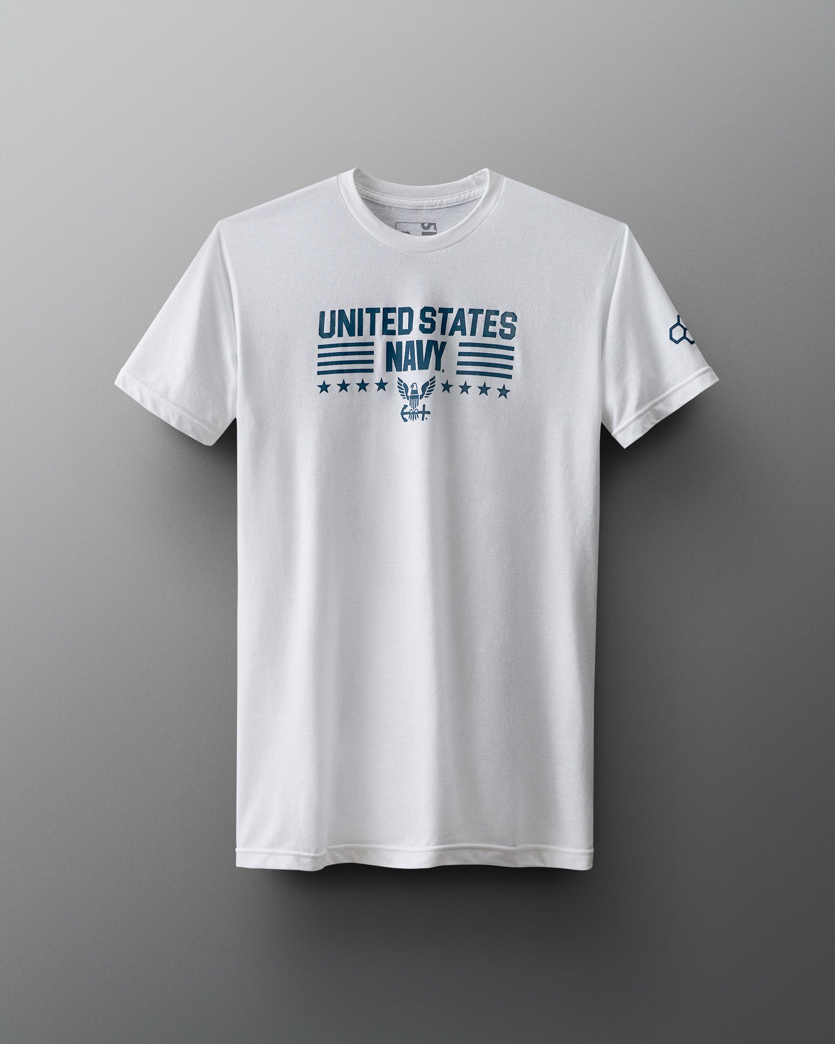 Front view of a white RUDIS T-shirt with bold blue text reading ‘United States Navy’ above an eagle insignia, with stars and horizontal lines in a military-style layout. RUDIS hexagon logo appears on the left sleeve.