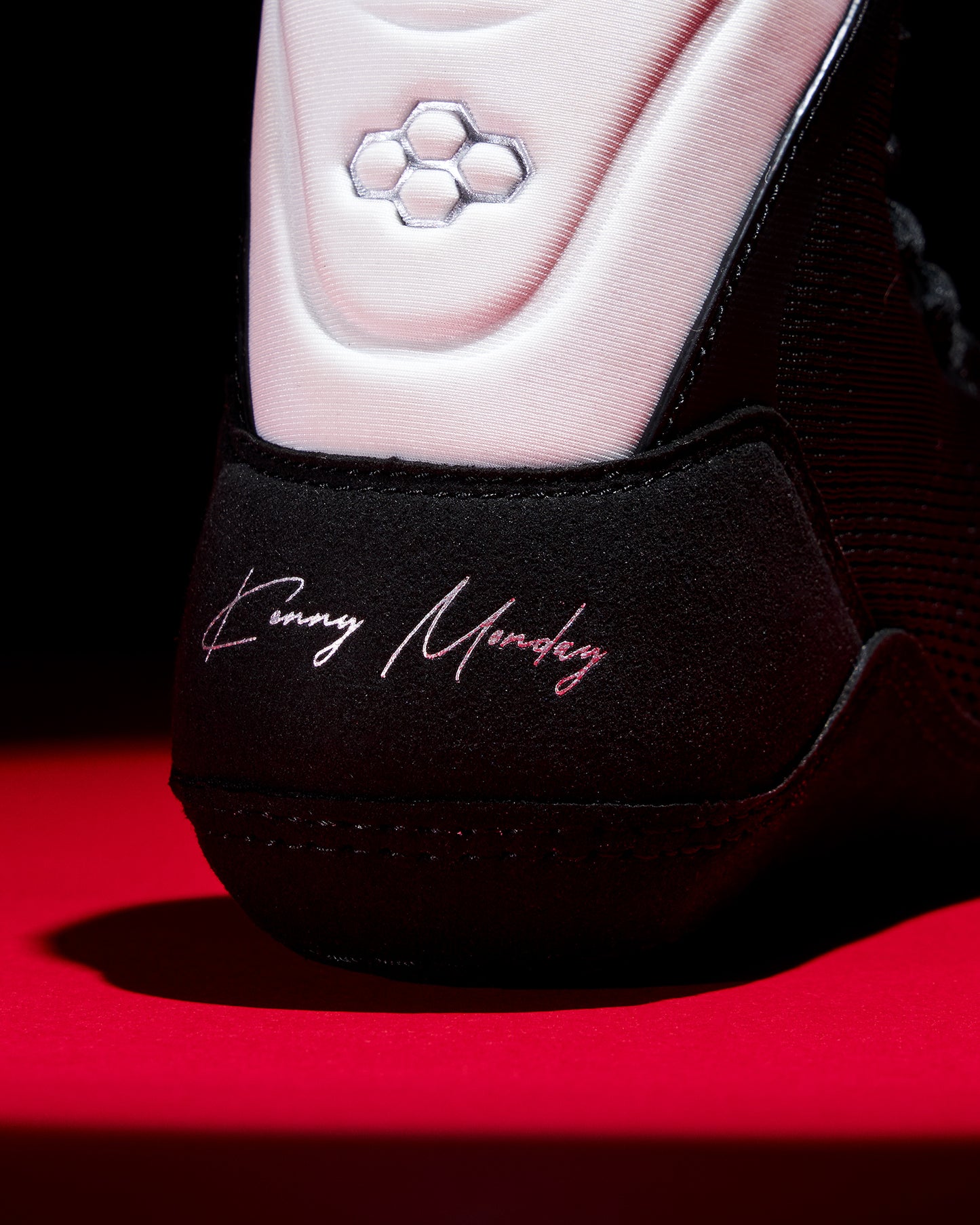 Close-up of a shoe with 'Kenny Morley' branding on a red background