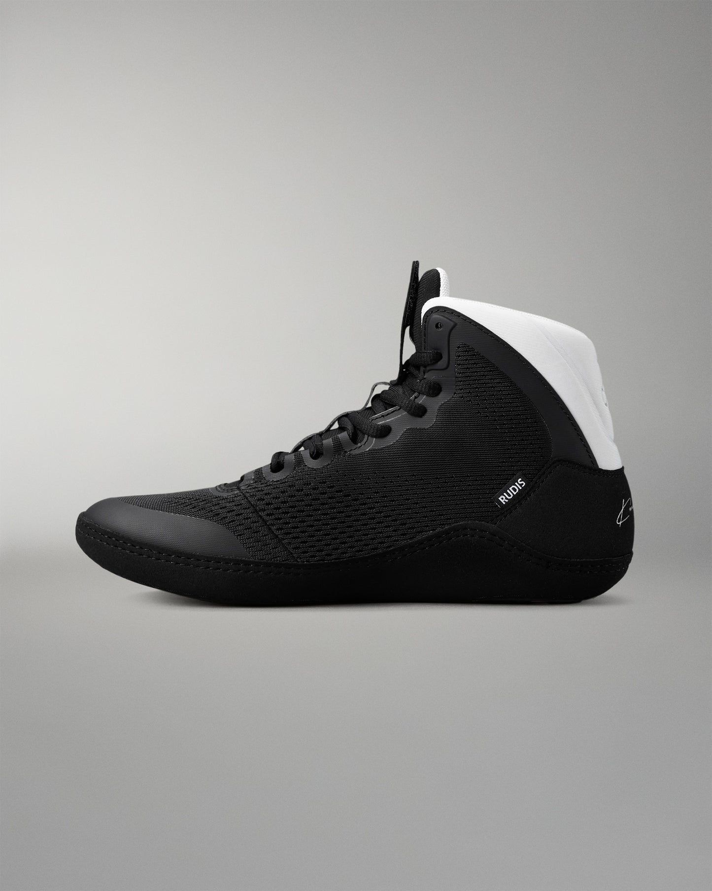 Black wrestling shoe with white heel on a gray background