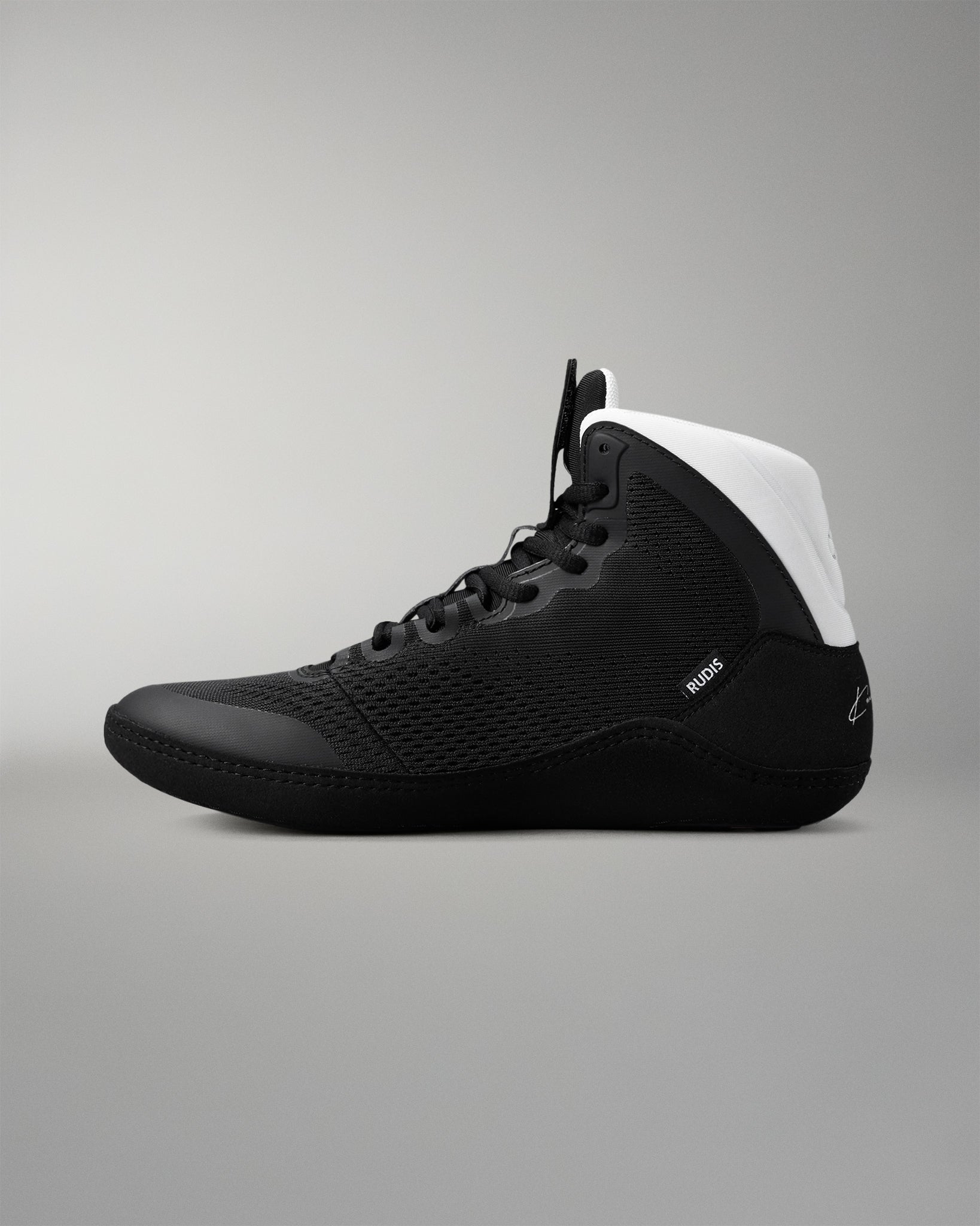 Black wrestling shoe with white heel on a gray background