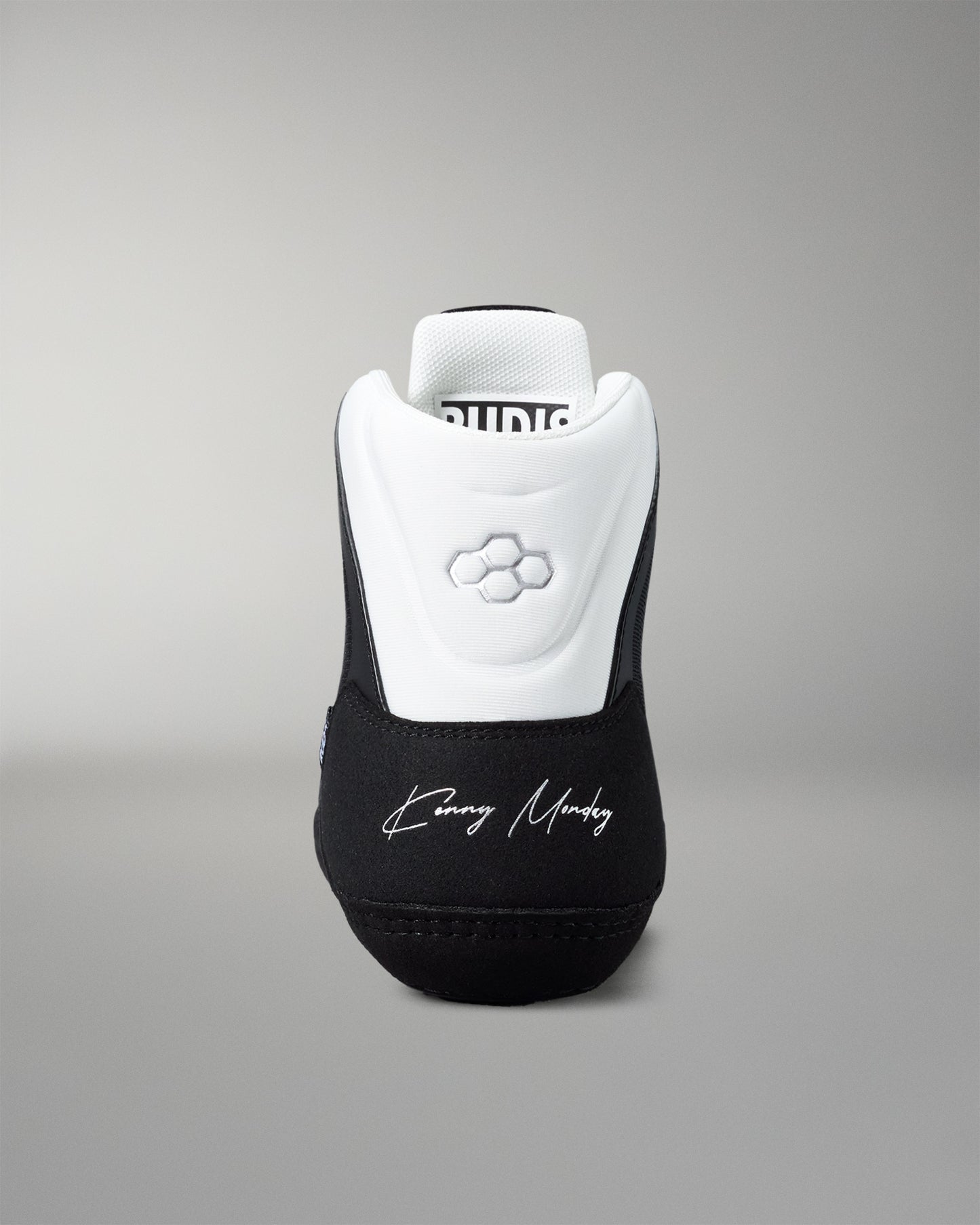 Black and white wrestling shoe with 'Kenny Monday' branding on a gray background