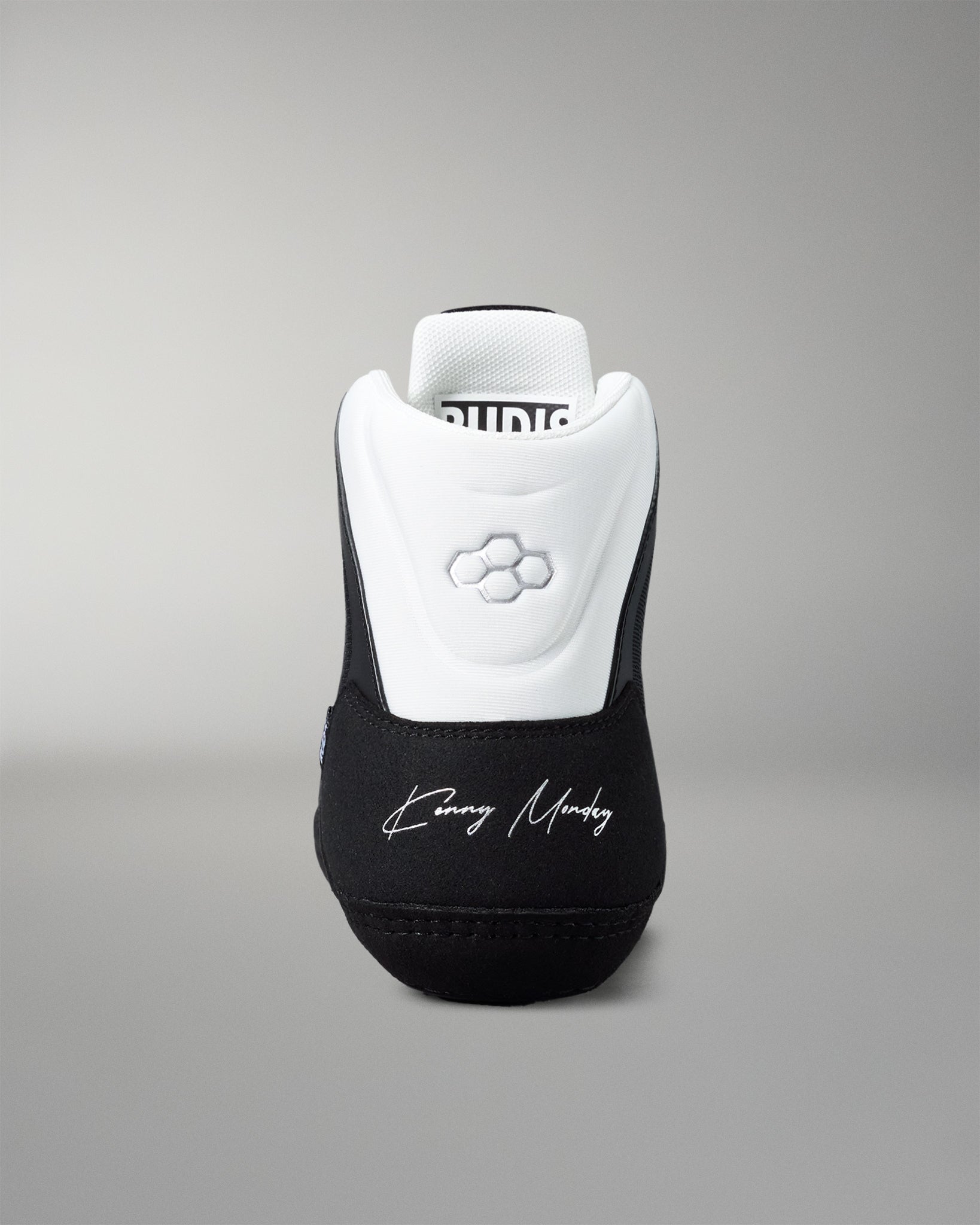 Black and white wrestling shoe with 'Kenny Monday' branding on a gray background