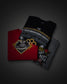 Three folded graphic T-shirts arranged in an overlapping stack on a dark gray background. The top shirt is black with a large white, gray, and gold championship graphic reading 'The Championship'; the middle shirt is red with a large 'Hawkey Nationals' logo in gold, black, and white; the bottom shirt is dark gray with a tiger graphic and partial text.