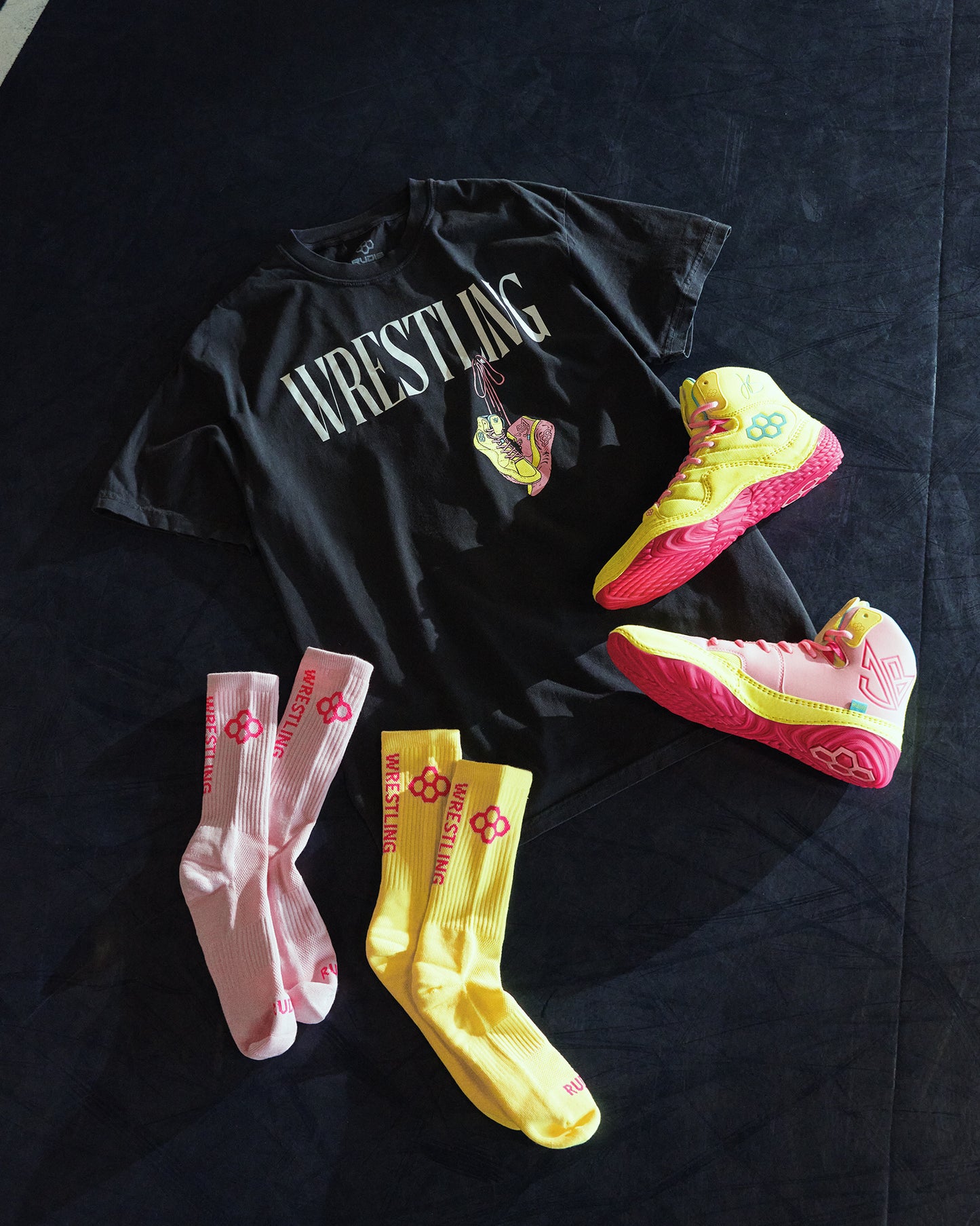Black wrestling t-shirt with colorful wrestling shoes and socks on a black background