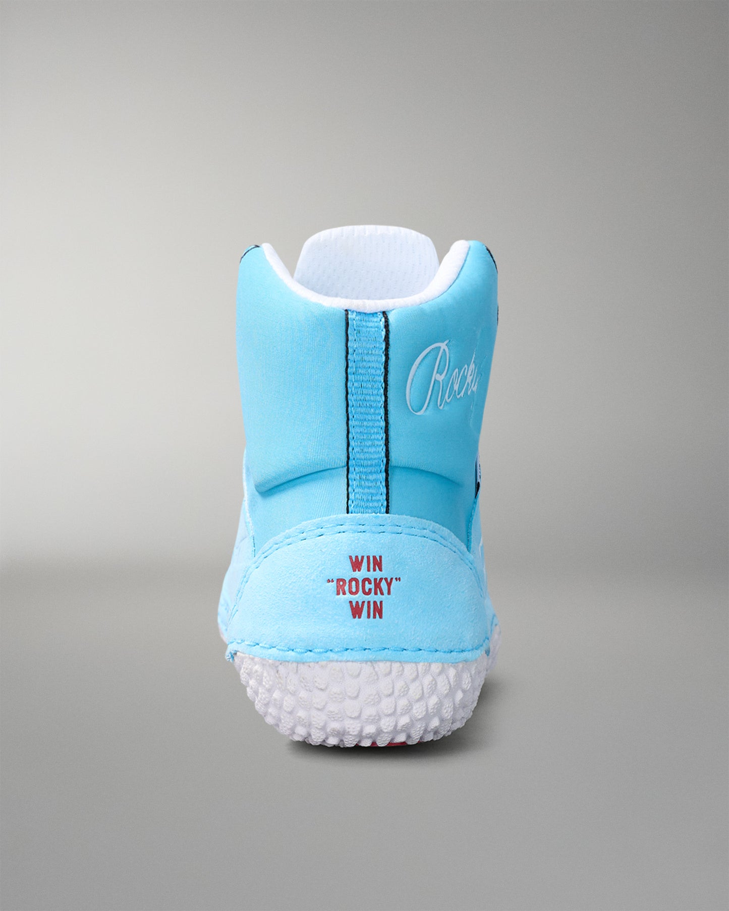 Light blue wrestling shoe with white sole on a gray background