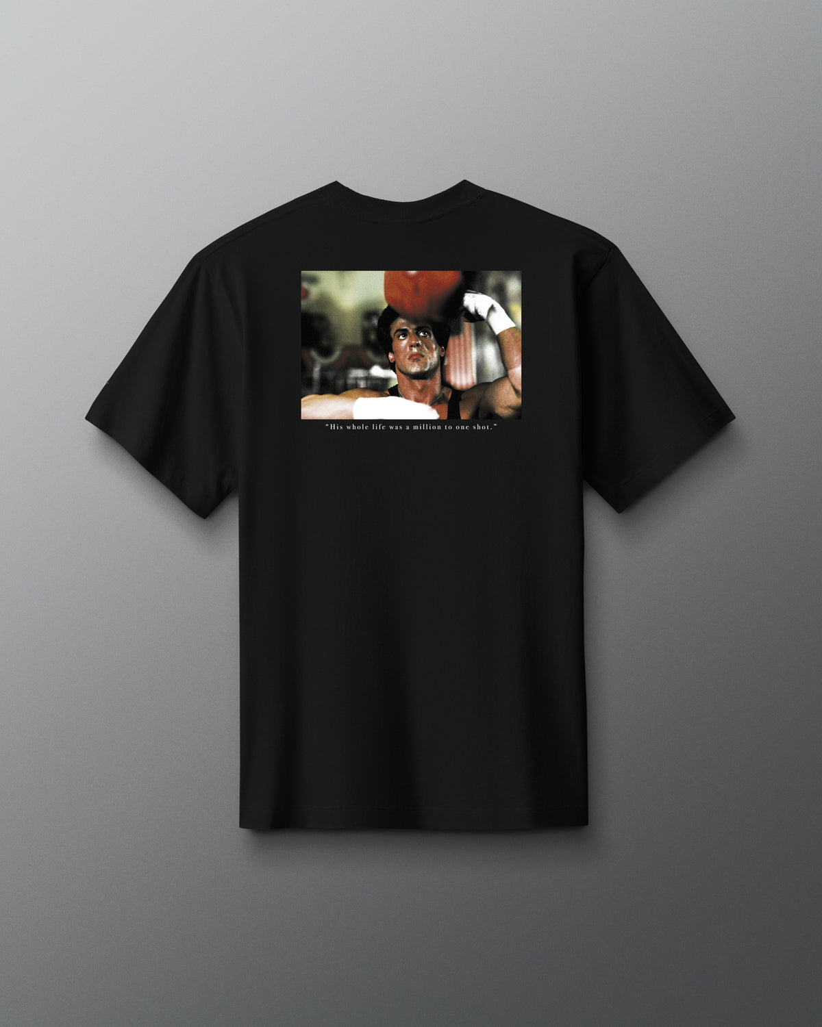 Back view of the RUDIS ROCKY Million to One Heavyweight T-Shirt in black, featuring a boxing film graphic and “His whole life was a million to one shot.” quote.