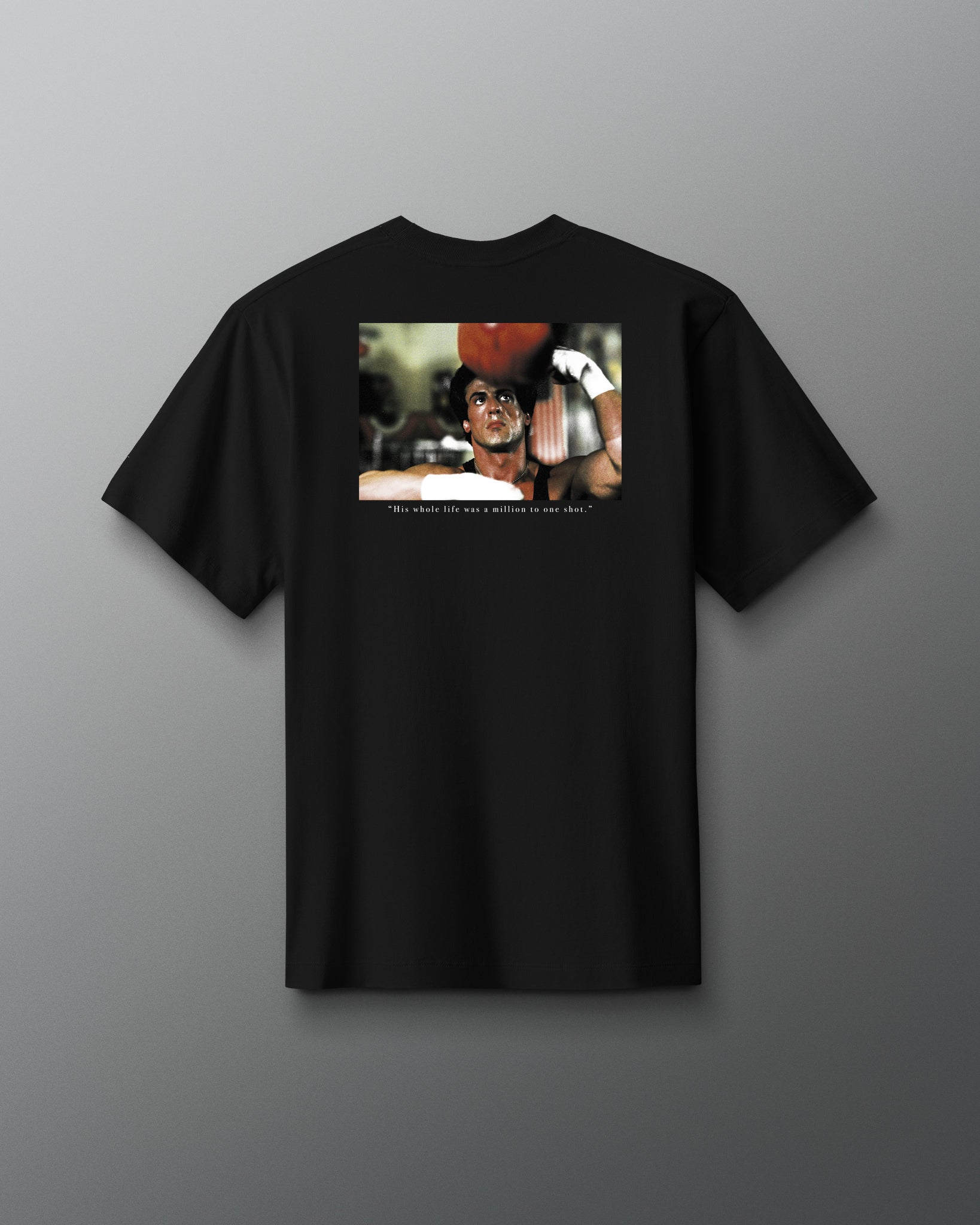 Back view of the RUDIS ROCKY Million to One Heavyweight T-Shirt in black, featuring a boxing film graphic and “His whole life was a million to one shot.” quote.