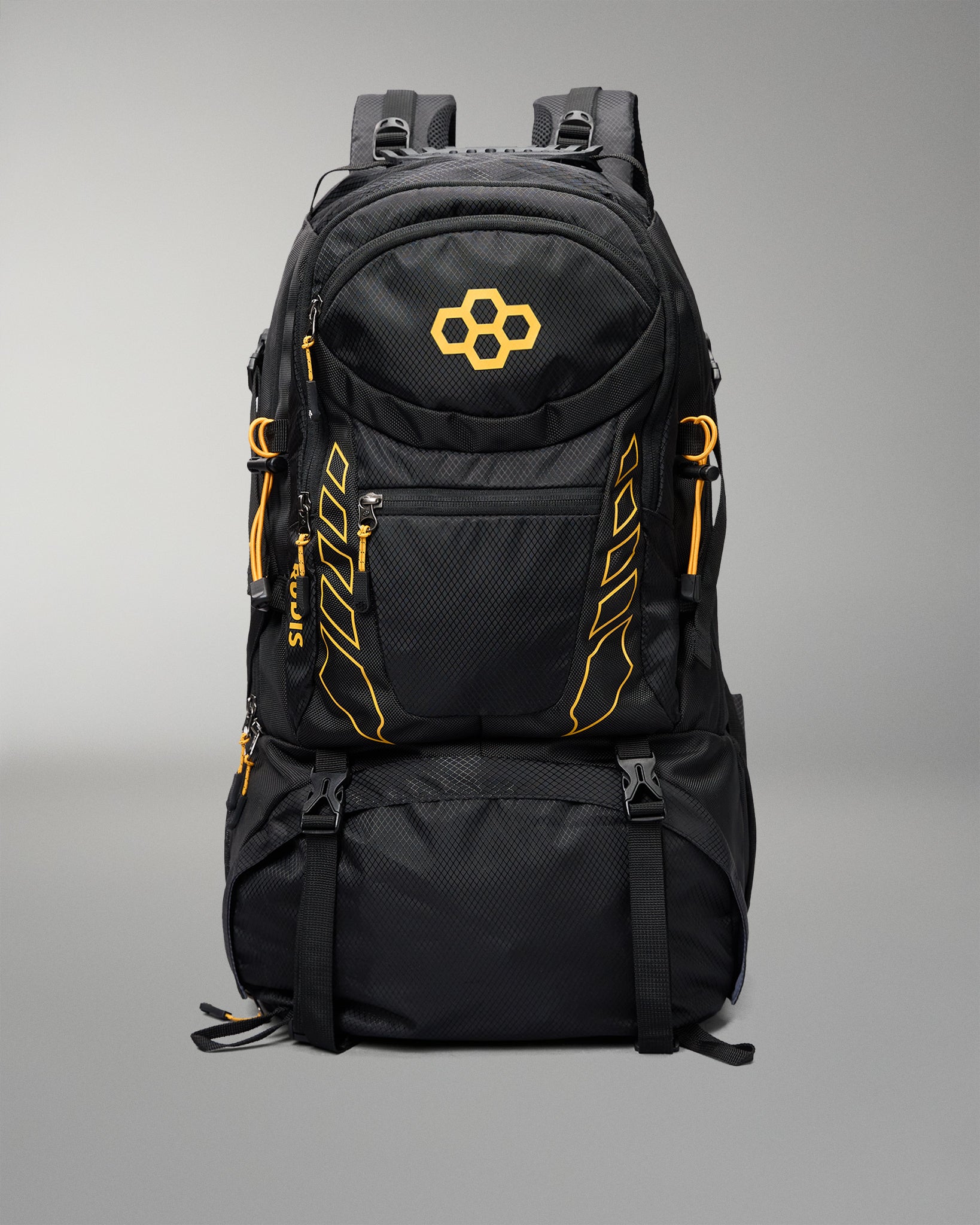 A black technical backpack with bright orange accents, including a geometric logo on the front pocket and vertical branding details, shown against a neutral gray background.