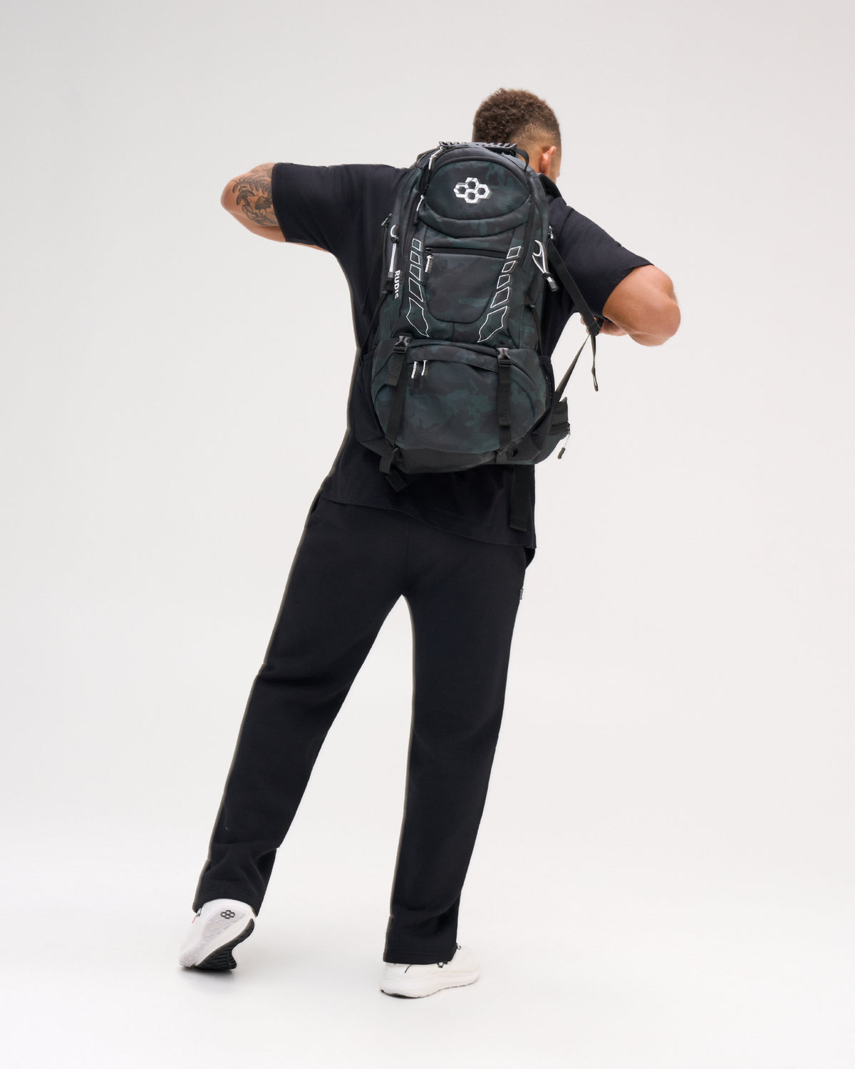 RUDIS Genesis Gearpack IV in Green Camo worn on the back, showcasing the full backpack profile, RUDIS branding, multiple storage compartments, adjustable straps, and large-capacity wrestling gear design.