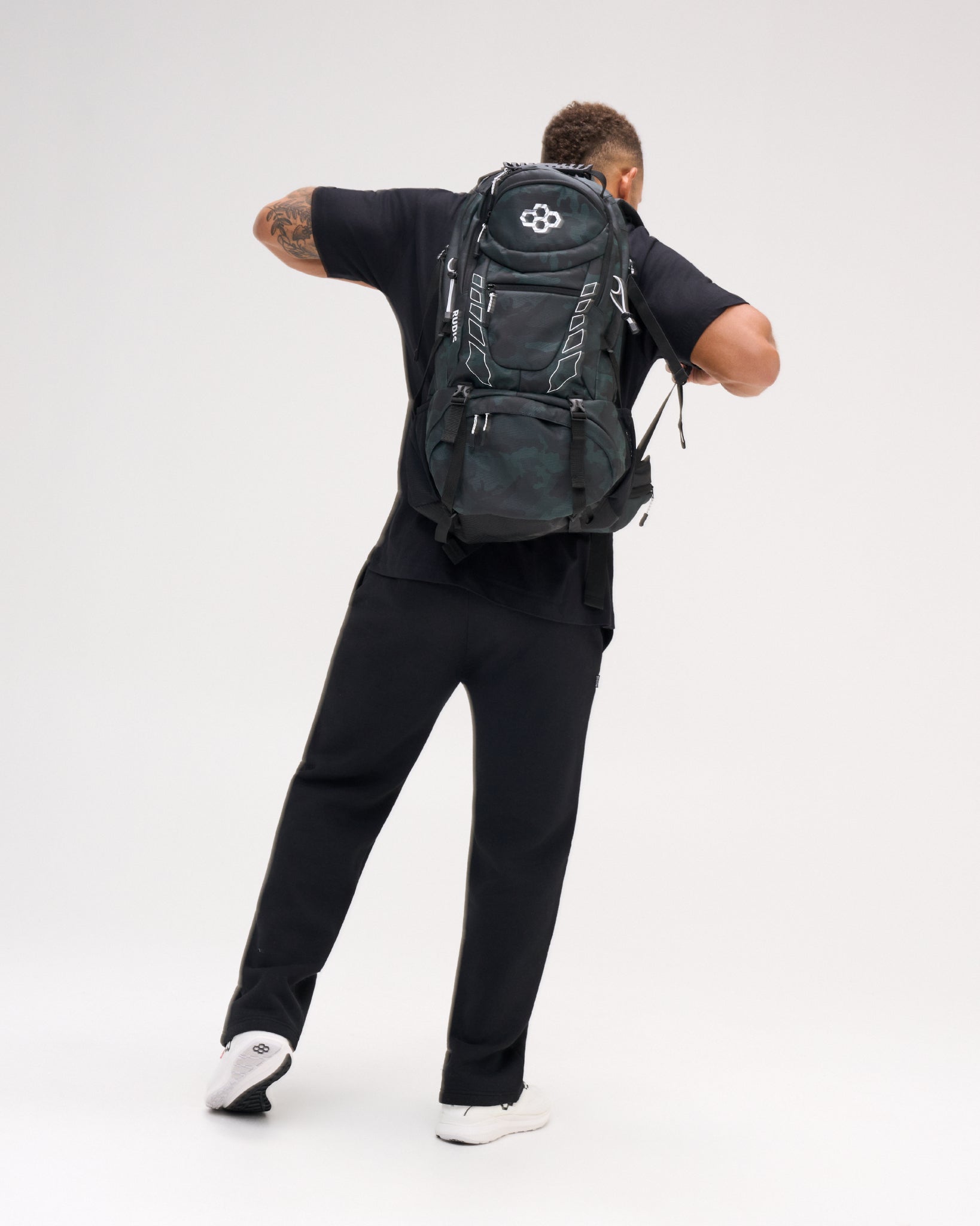 RUDIS Genesis Gearpack IV in Green Camo worn on the back, showcasing the full backpack profile, RUDIS branding, multiple storage compartments, adjustable straps, and large-capacity wrestling gear design.
