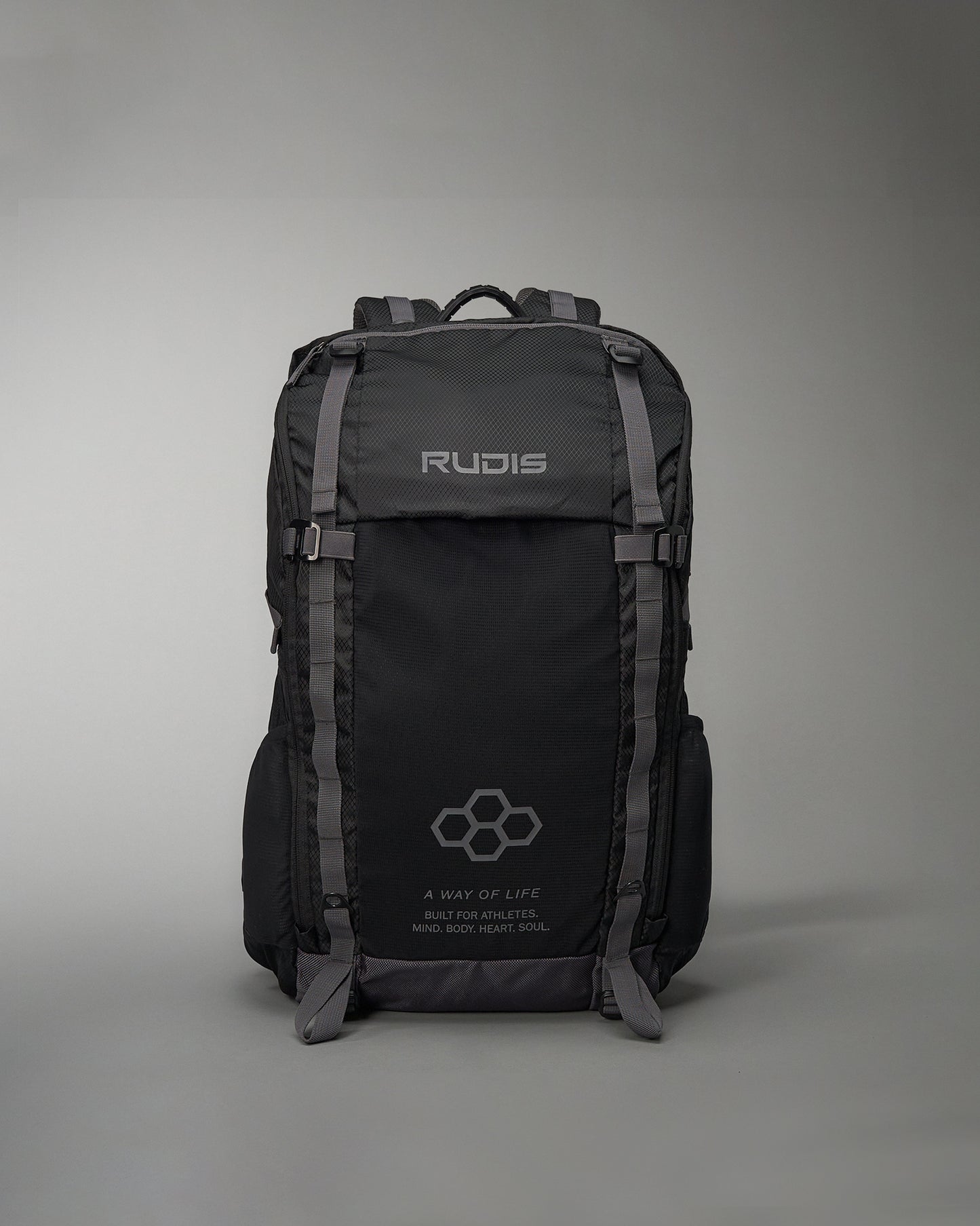 A durable black backpack designed for athletes featuring the brand name RUDIS prominently displayed and motivational text about building a healthy lifestyle