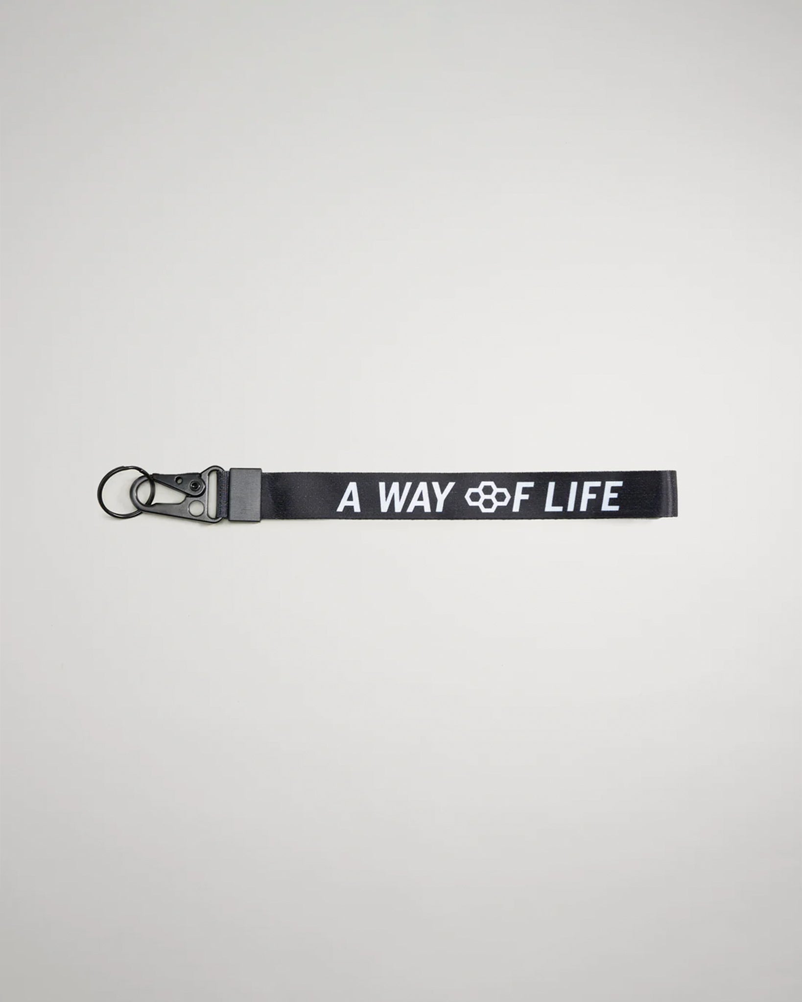A black fabric strap featuring the phrase A WAY OF LIFE in bold white letters accompanied by a keyring attachment and clip