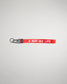 A vibrant red keychain strap featuring the phrase A WAY OF LIFE in bold white lettering designed for functional and stylish use