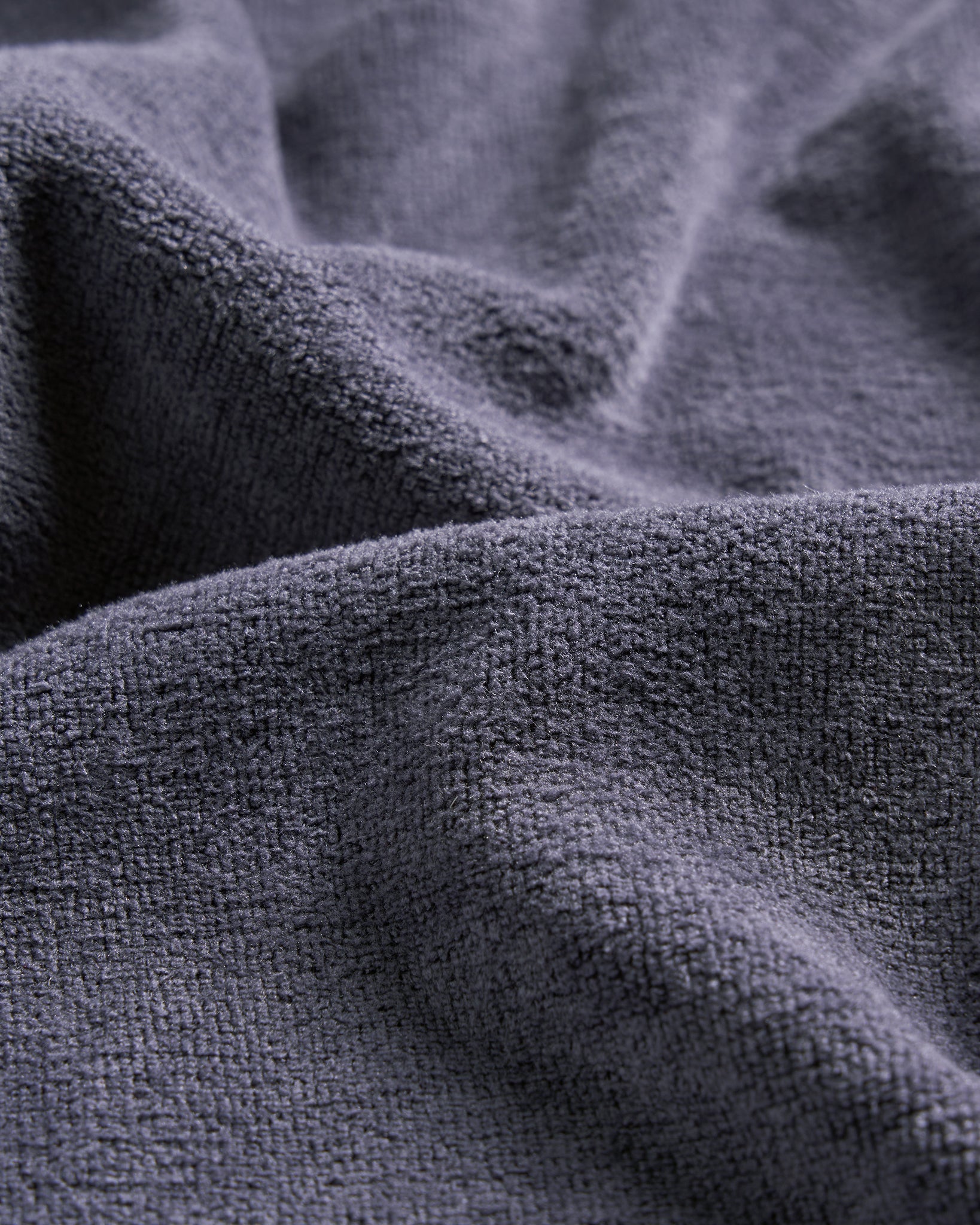 A close-up view of textured dark gray fabric showcasing its soft and plush surface characteristics