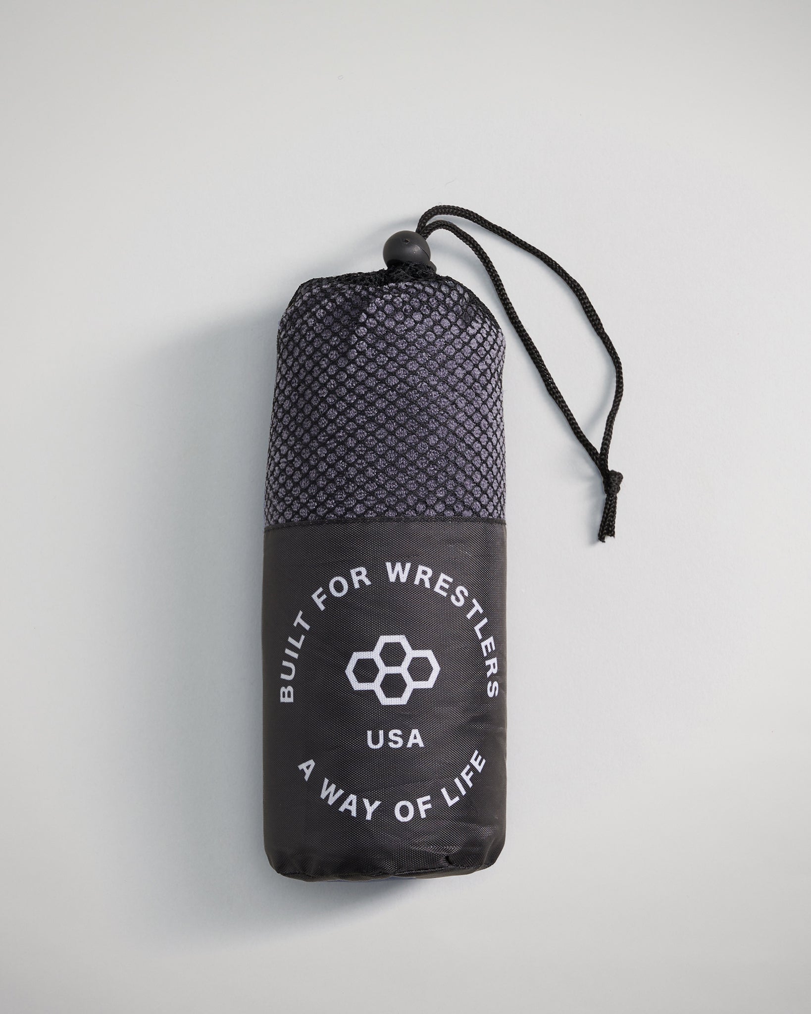 A compact black and gray drawstring bag designed for wrestlers featuring a mesh top and bold white text indicating its purpose and origin