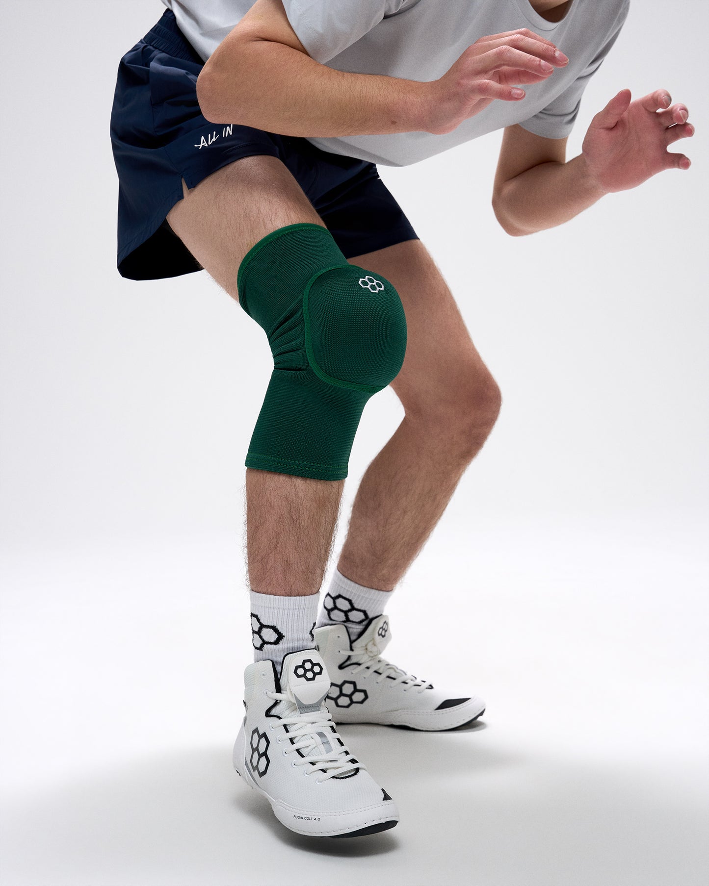 Person wearing a green knee pad on a white background