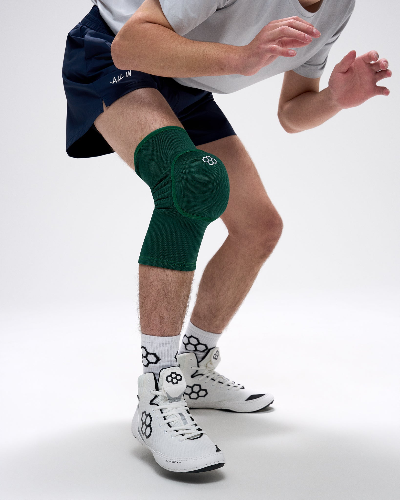 Person wearing a green knee pad on a white background