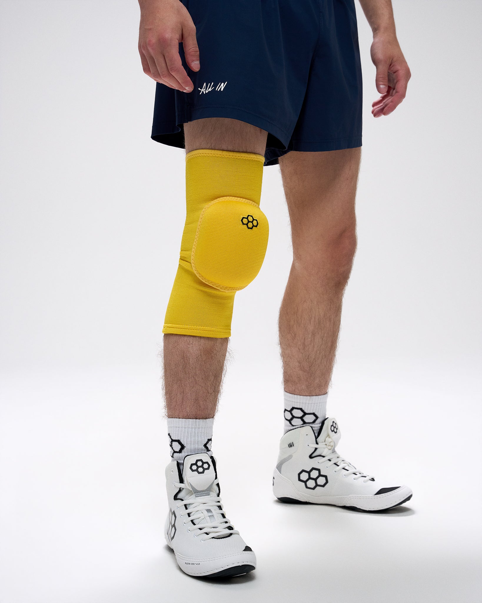 Person wearing a yellow knee pad on a white background