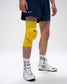 Person wearing a yellow knee pad on a white background