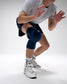 Person wearing blue knee pads and white sneakers on a plain background
