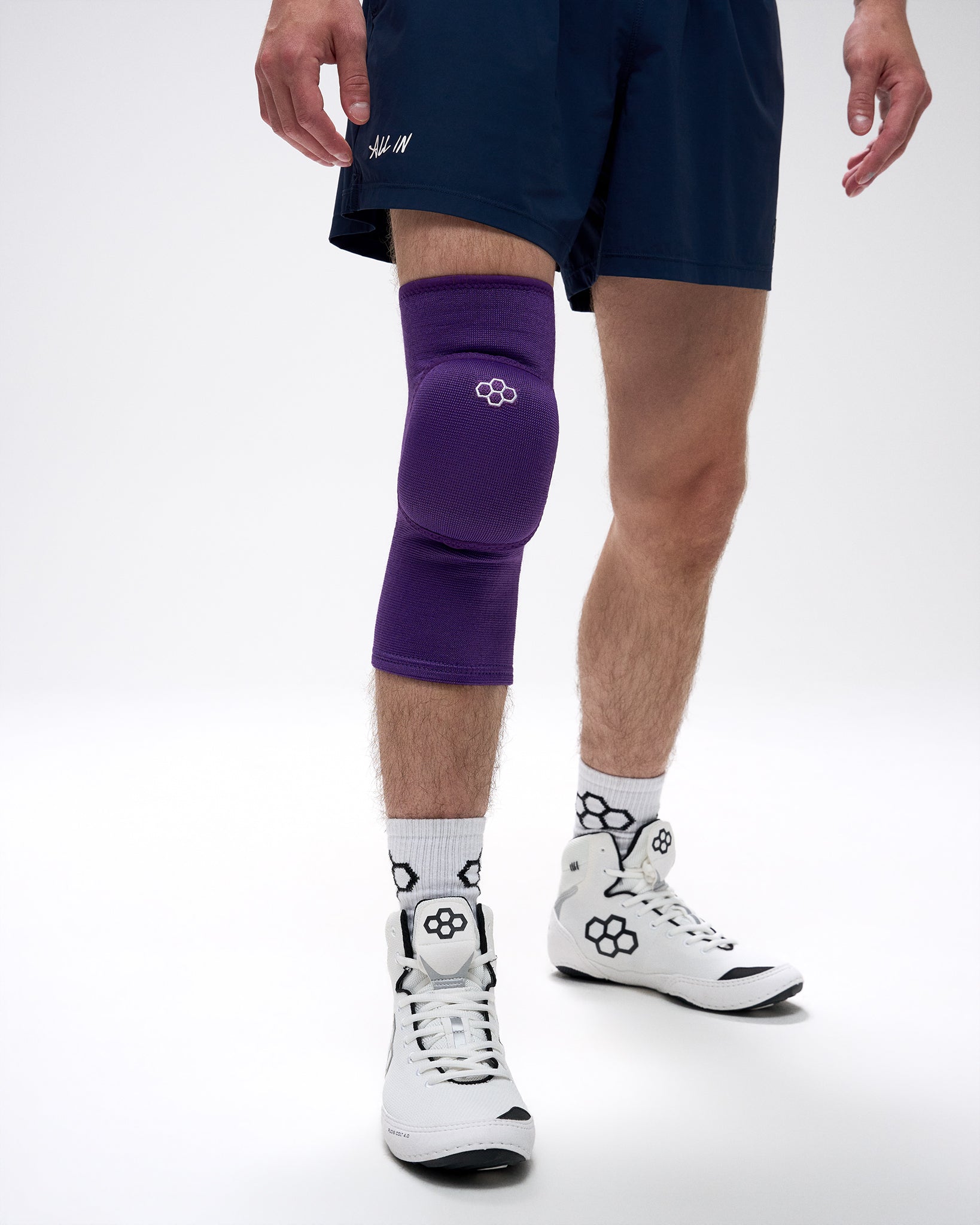 Person wearing a purple knee pad on a white background
