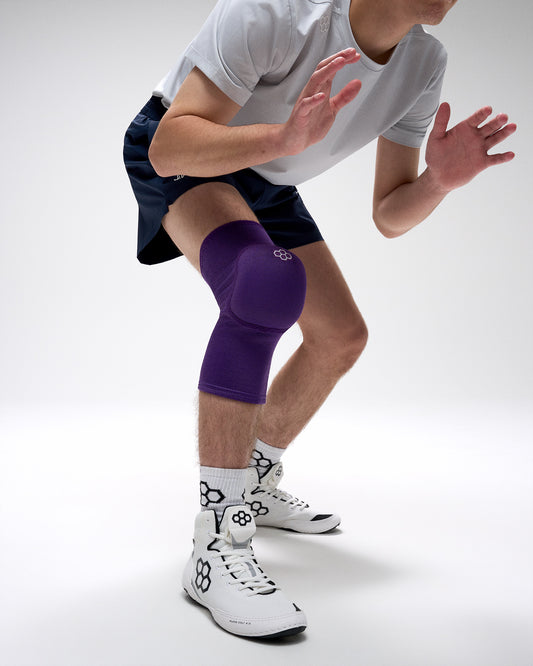 Person wearing a purple knee brace on a white background