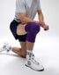 Person wearing a purple knee brace on a white background