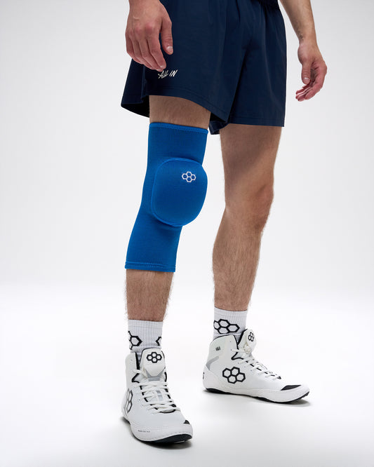 Person wearing a blue knee pad on a white background