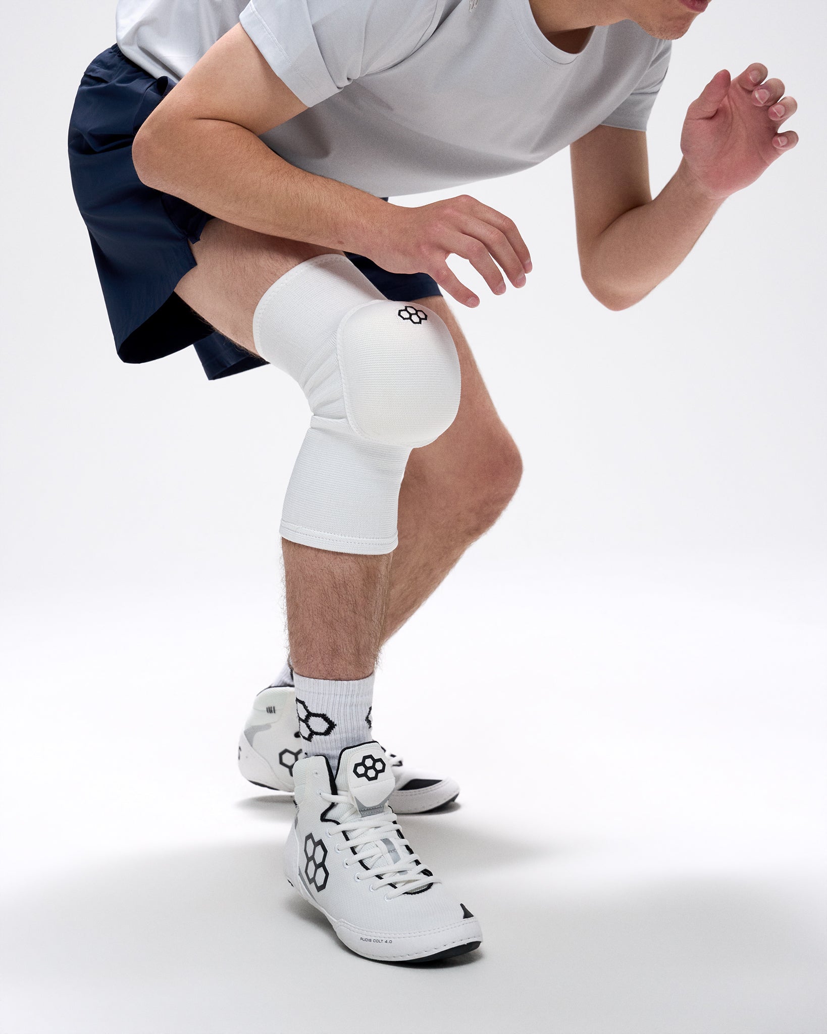 Person wearing a white knee pad on a plain background