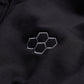 This image features a close-up of a black fabric surface adorned with an embroidered hexagonal logo in a lighter gray tone showcasing a sleek and modern design aesthetic