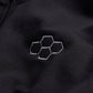 This image features a close-up of a black fabric surface adorned with an embroidered hexagonal logo in a lighter gray tone showcasing a sleek and modern design aesthetic