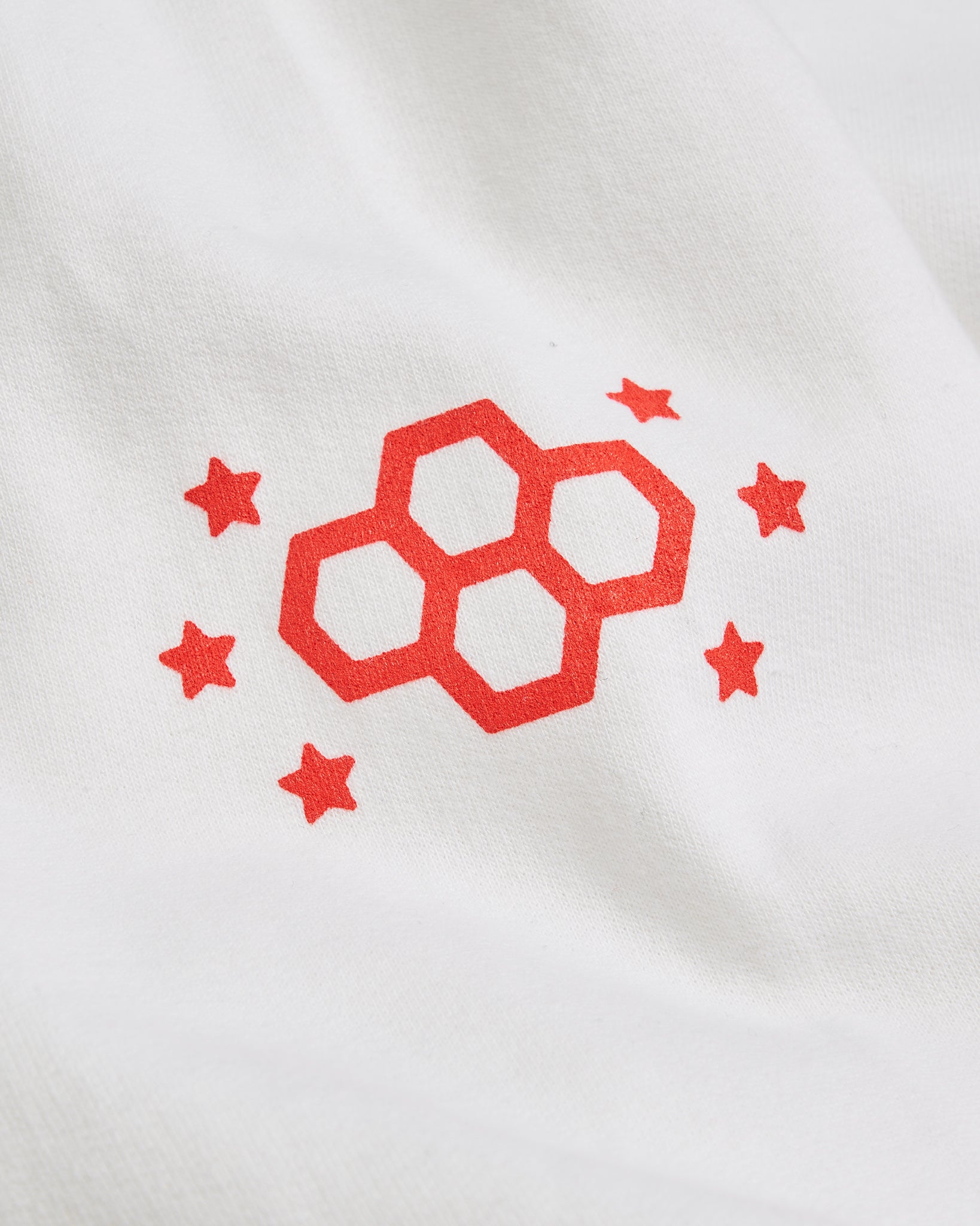 A bold red logo featuring interconnected hexagons and stars on a white fabric background