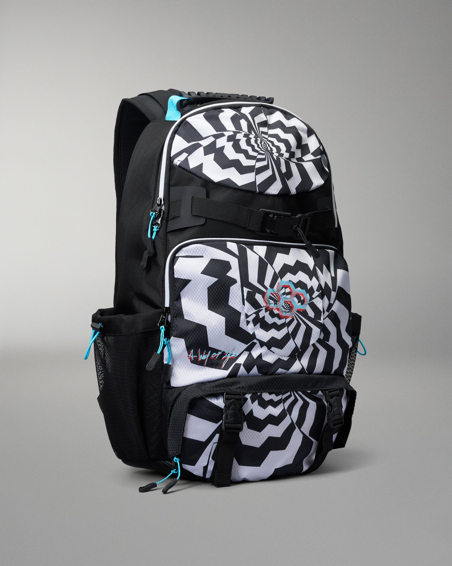 A black and white patterned backpack with a spiral design on the front pocket, black side pockets, and bright turquoise zipper pulls, shown on a neutral gray background.
