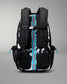 A black and white patterned backpack shown from the back, featuring a prominent bright blue vertical strap with the brand name 'RUDIS' printed in white, and small blue zipper pulls on the side mesh pockets.