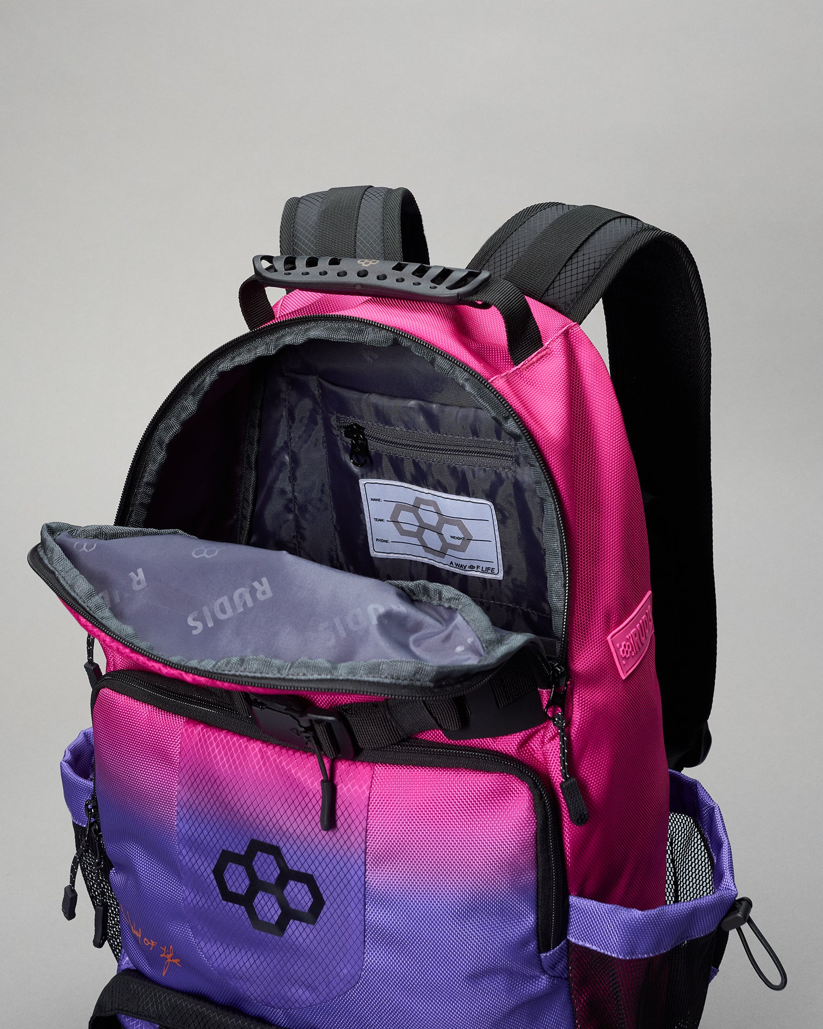 Pink and purple backpack with open front pocket on a gray background
