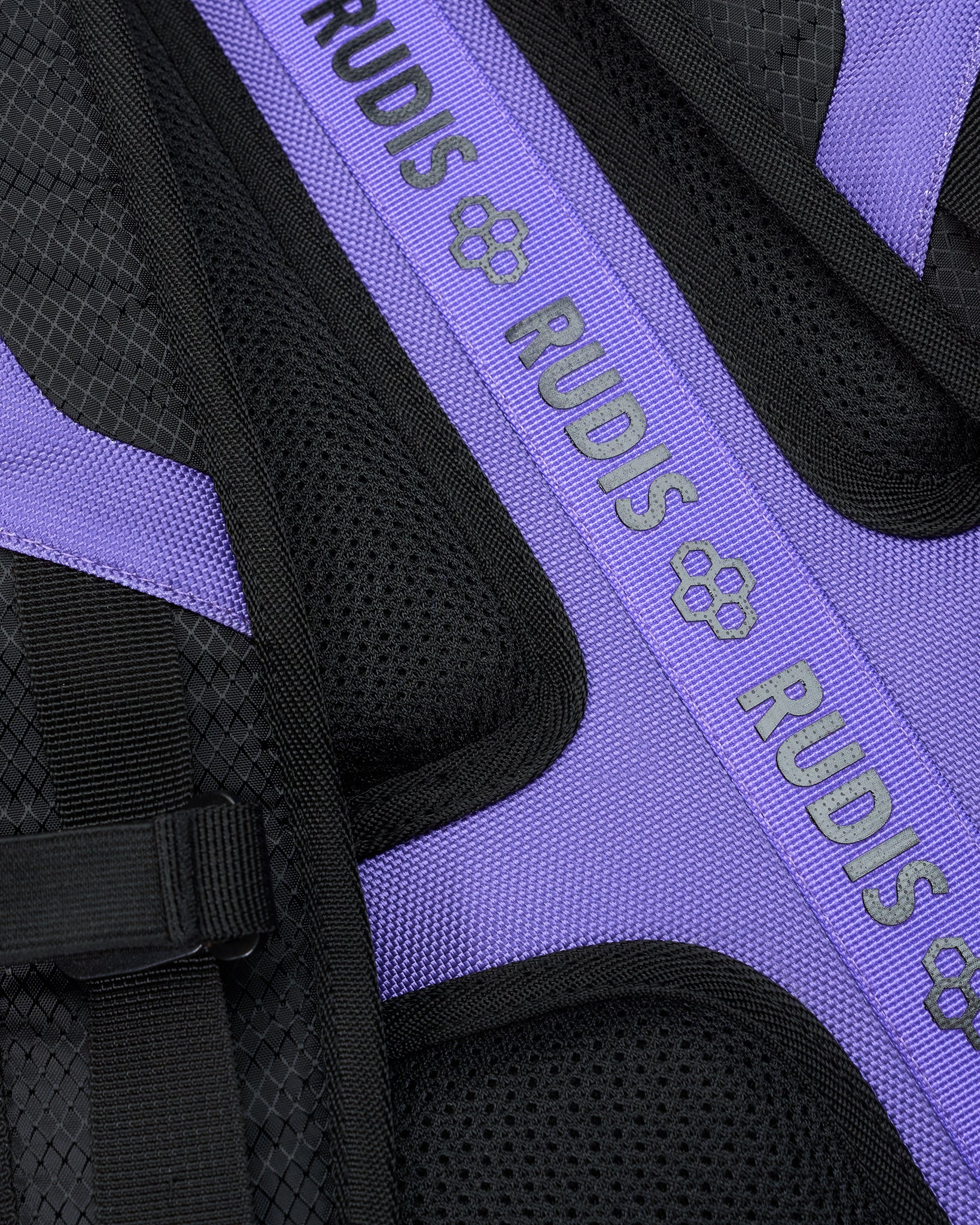 Close-up of a purple and black backpack with 'RUDIS' branding.