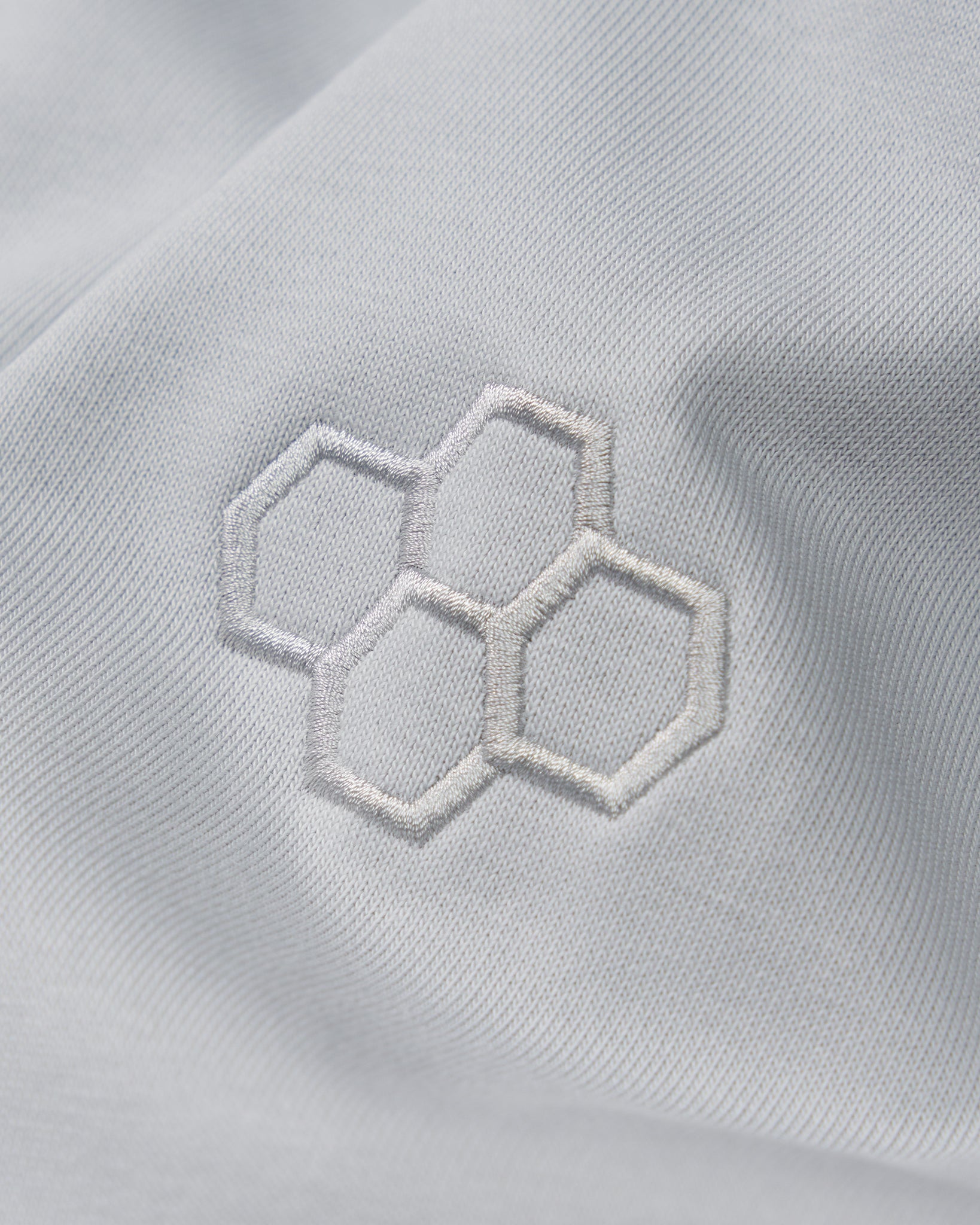 Close-up of a white fabric with embroidered hexagonal pattern