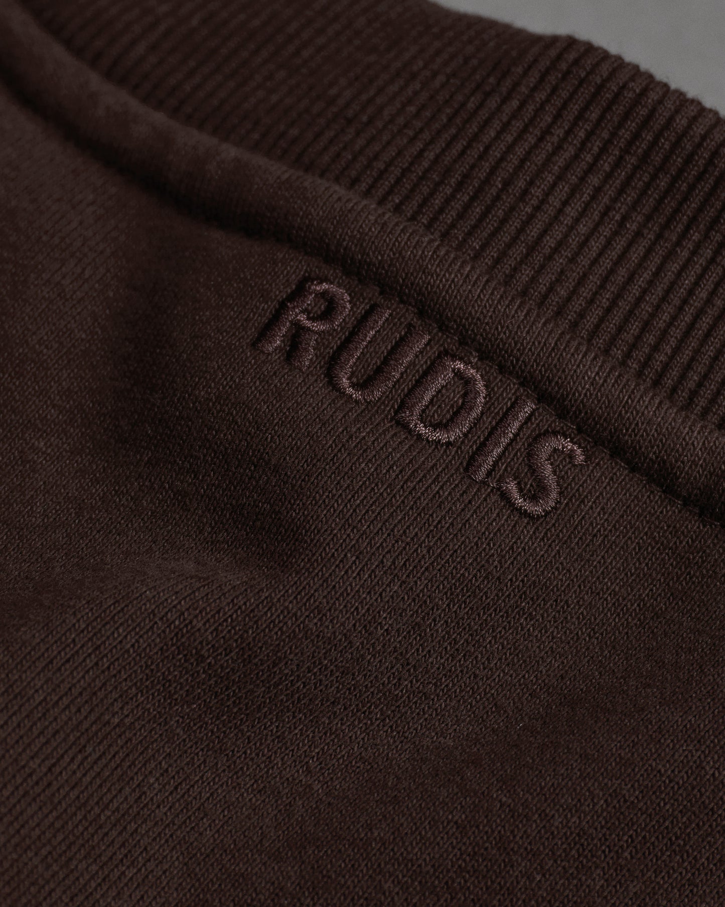Brown fabric with 'RUDIS' branding on a dark background