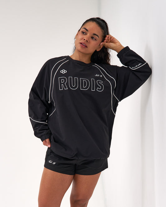 Person wearing a black 'RUDIS' sweatshirt and shorts on a white background
