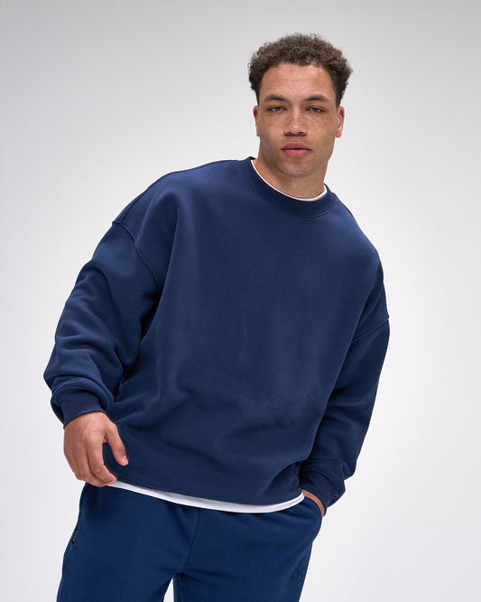 Man wearing a navy blue sweatshirt and pants on a white background