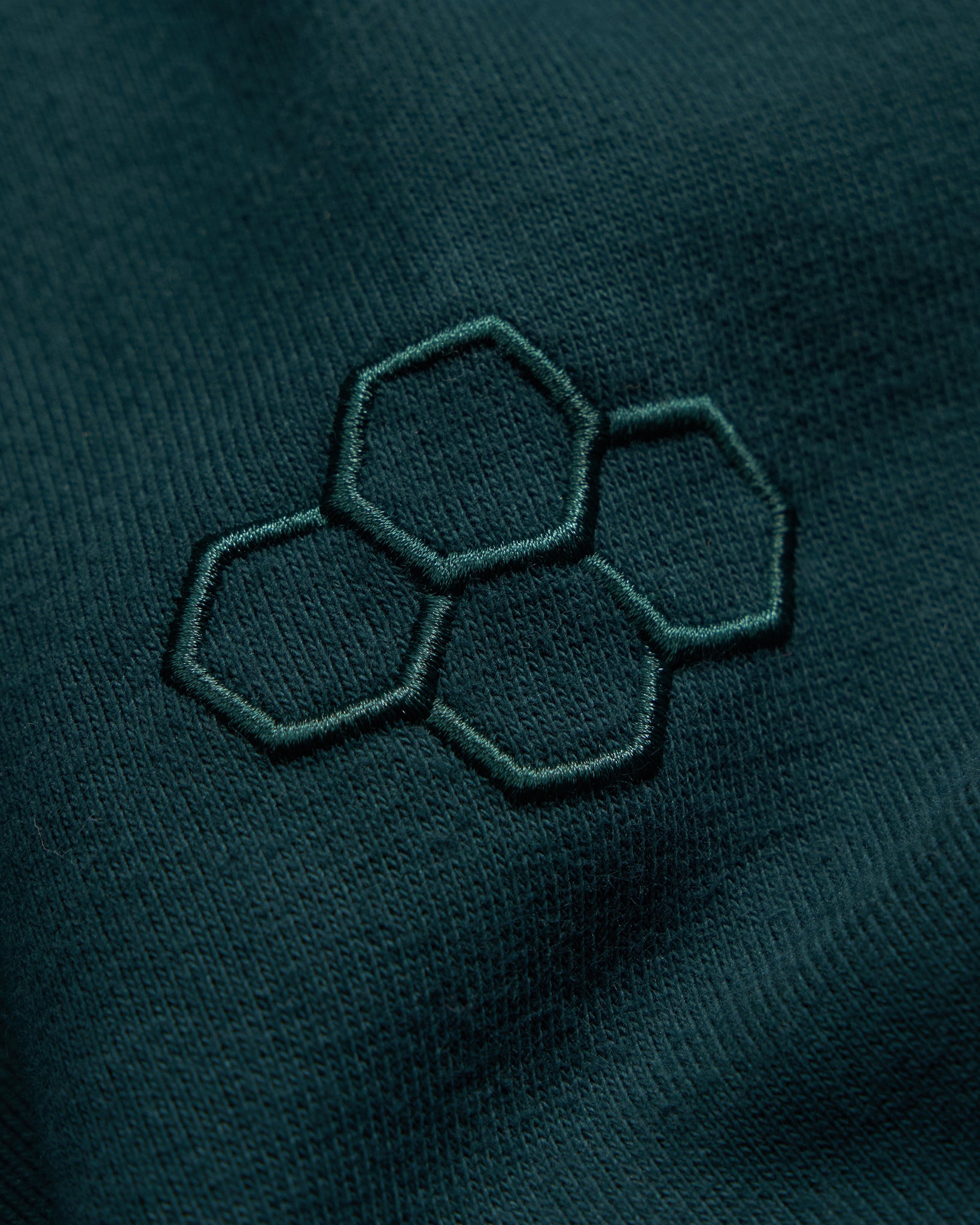 Hexagonal pattern on a dark green fabric surface