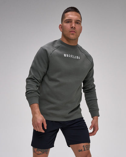Man wearing a gray sweatshirt with 'Wrestling' text on a gray background