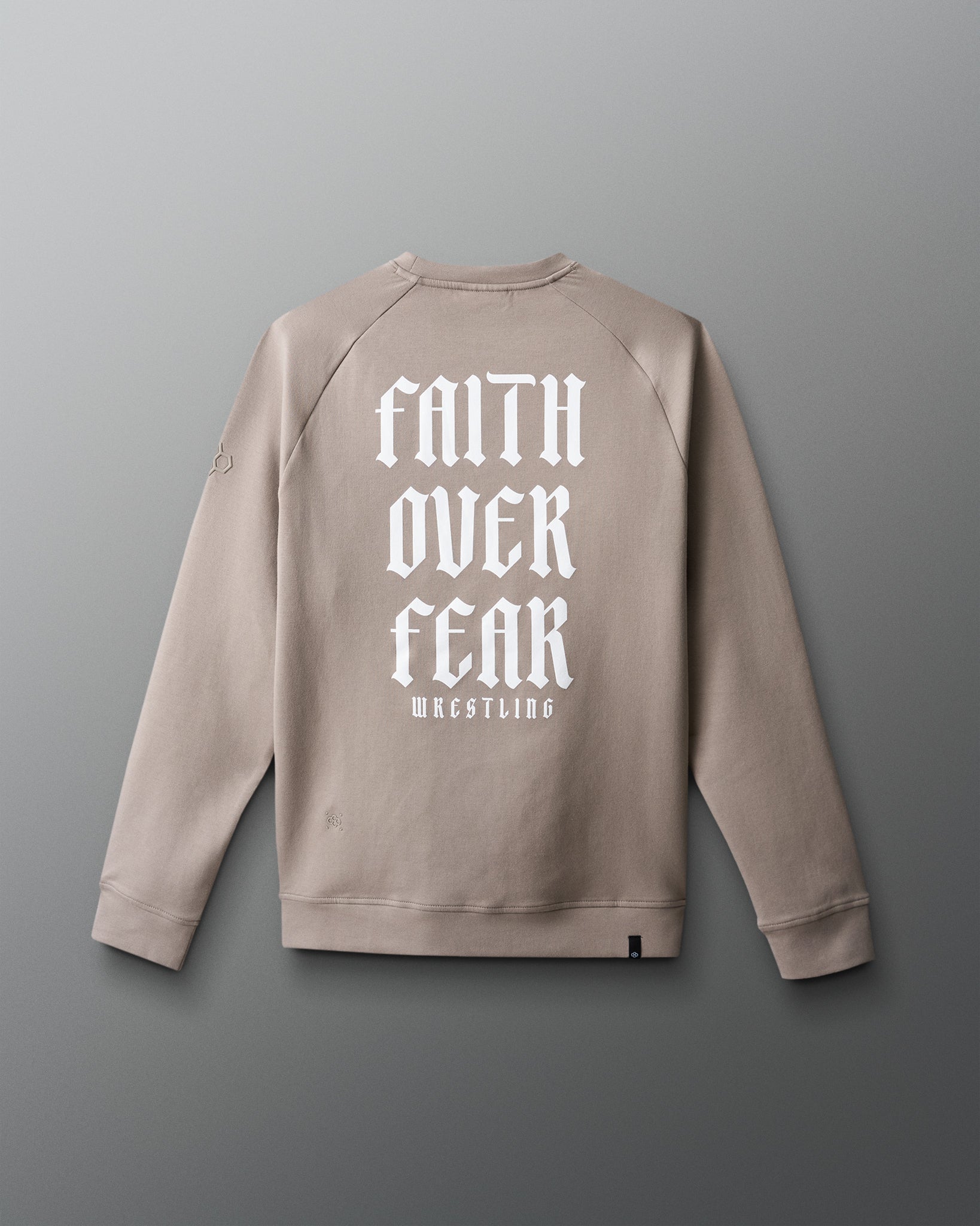 Beige sweatshirt with 'Faith Over Fear Wrestling' text on the back against a gray background