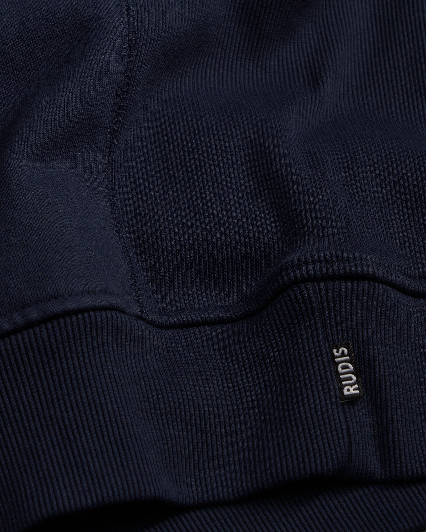 Navy blue sweatshirt with 'RUDIS' logo on the chest pocket