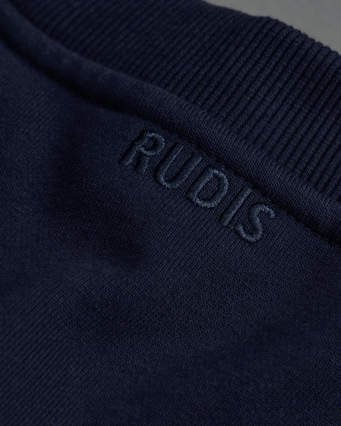 Navy blue fabric with 'RUDIS' branding