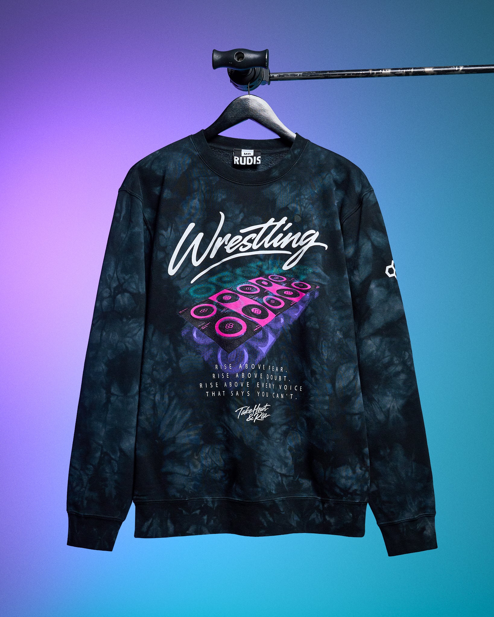 Tie-dye sweatshirt with 'Wrestling' text on a hanger against a gradient background