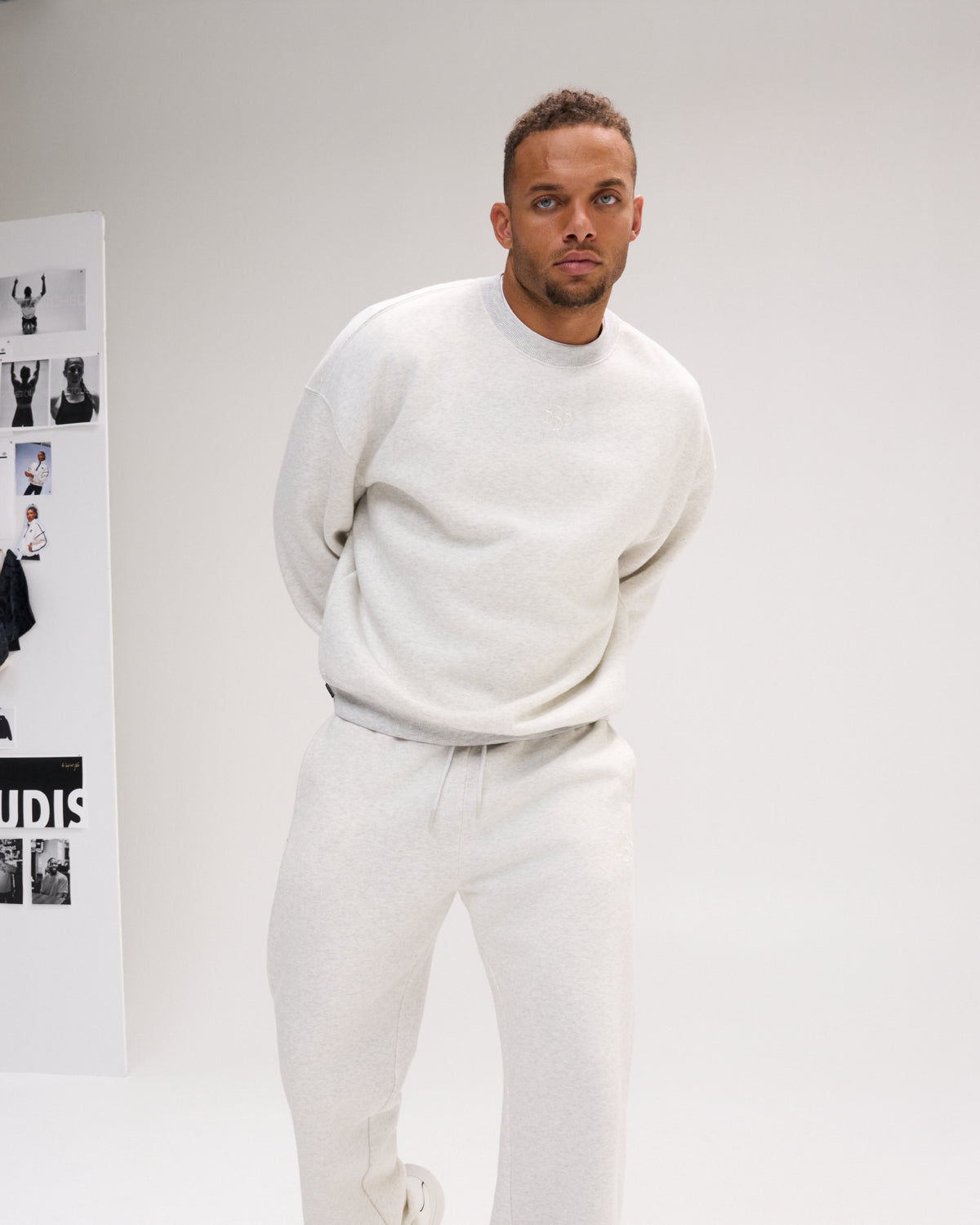Man modeling the RUDIS Hex Relaxed Comfort Fleece Crewneck in Heather Silver, paired with matching fleece pants for a coordinated casual look.
 Copy alt text