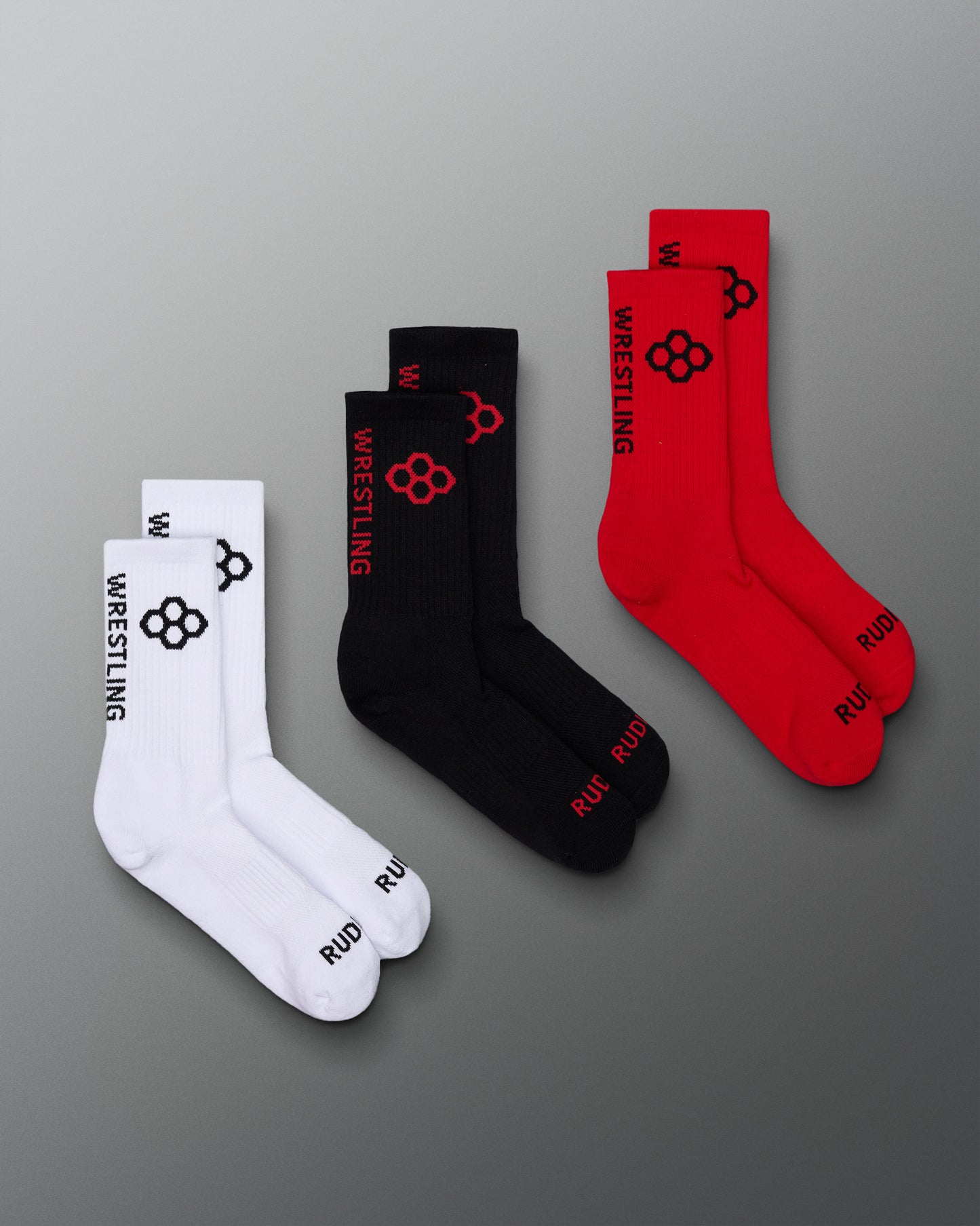 Set of three socks in red, black, and white with wrestling design on a gray background