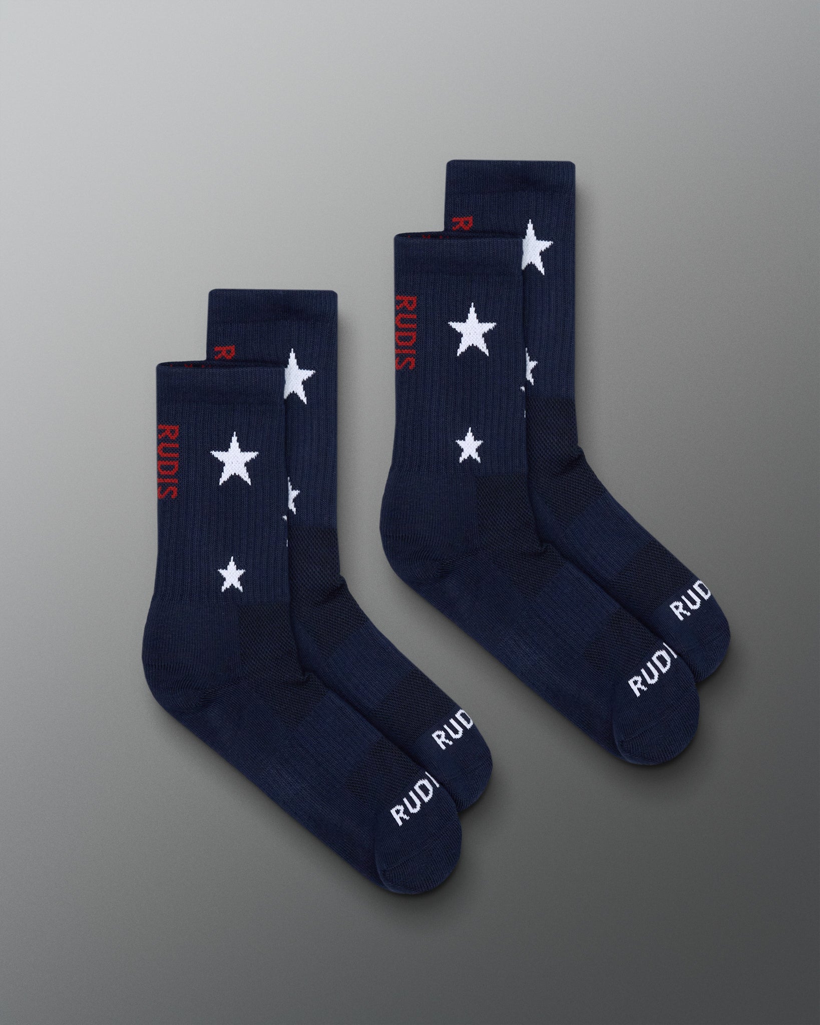 Navy socks with white star patterns and red text on a gray background