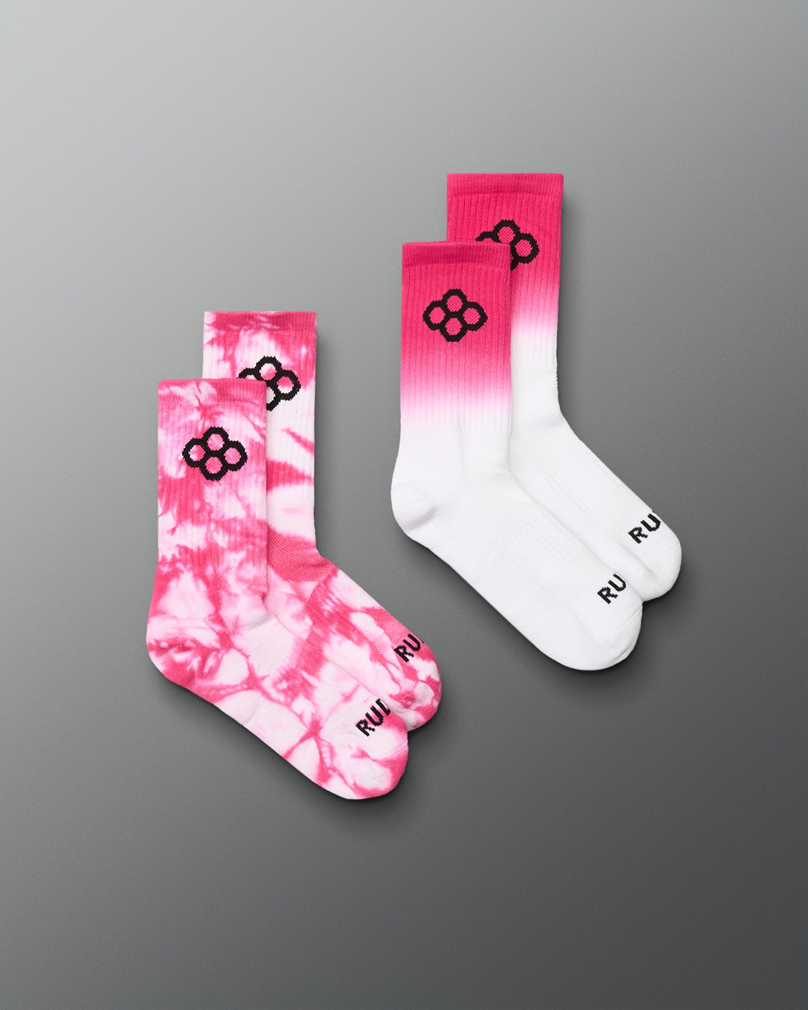 Two pairs of socks with pink and white tie-dye pattern and white color on a gray background